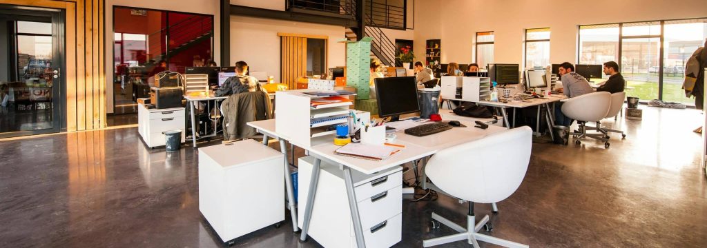 pexels-photo-1170412-1170412 A spacious and modern open-plan office with natural lighting and employees working at desks.